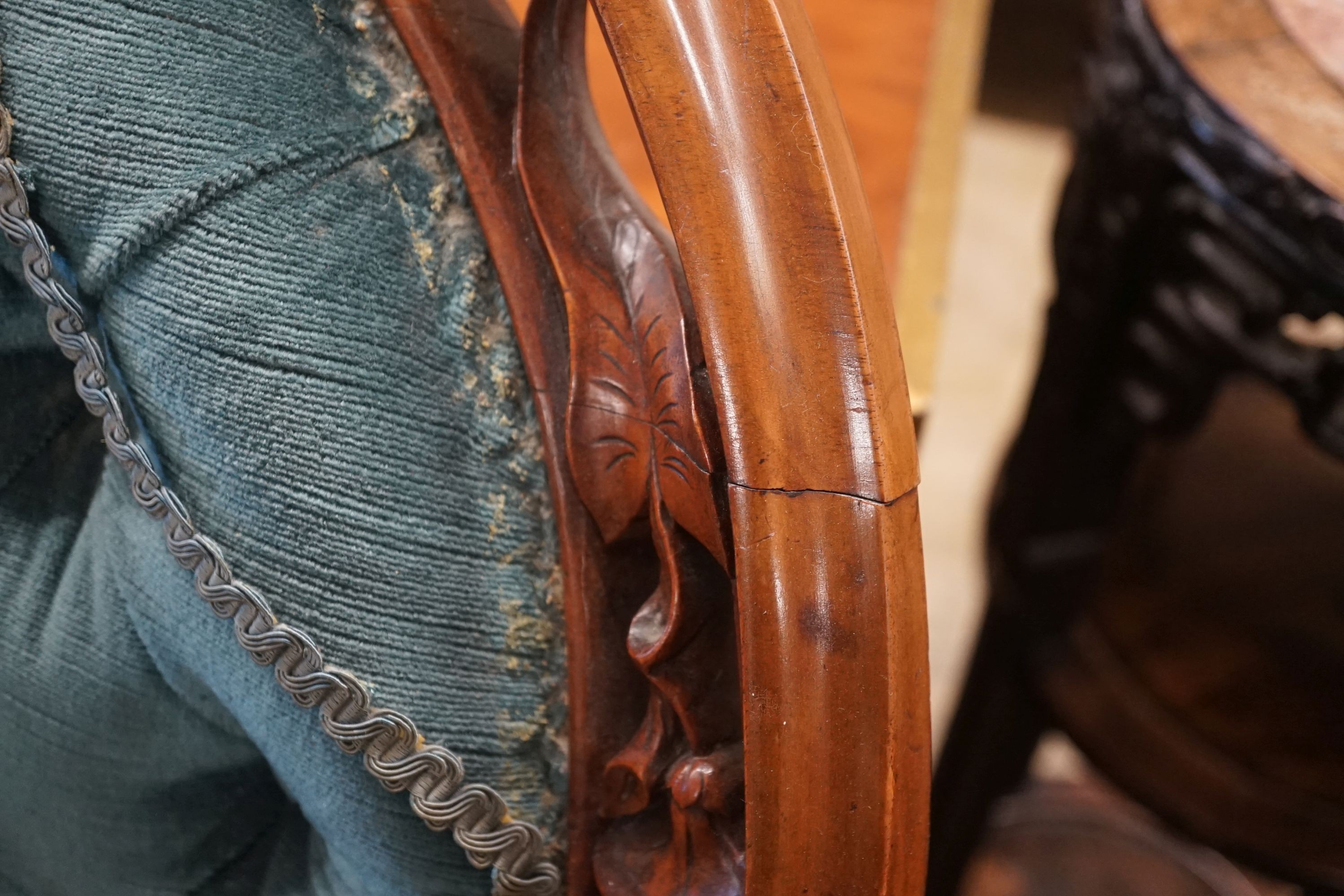 A Victorian carved mahogany spoon back salon chair with buttoned blue upholstery